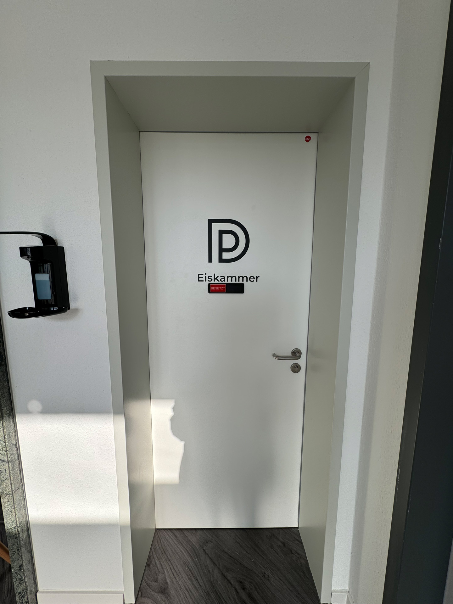 Weisse Tuer mit Logo und Beschriftung Eiskammer und rotem Besetzt Schild